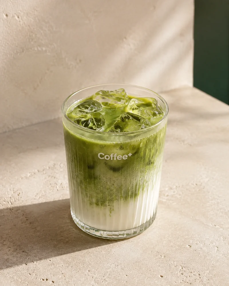 Matcha Latte auf Eis in einem geriffelten Coffee+ Glas